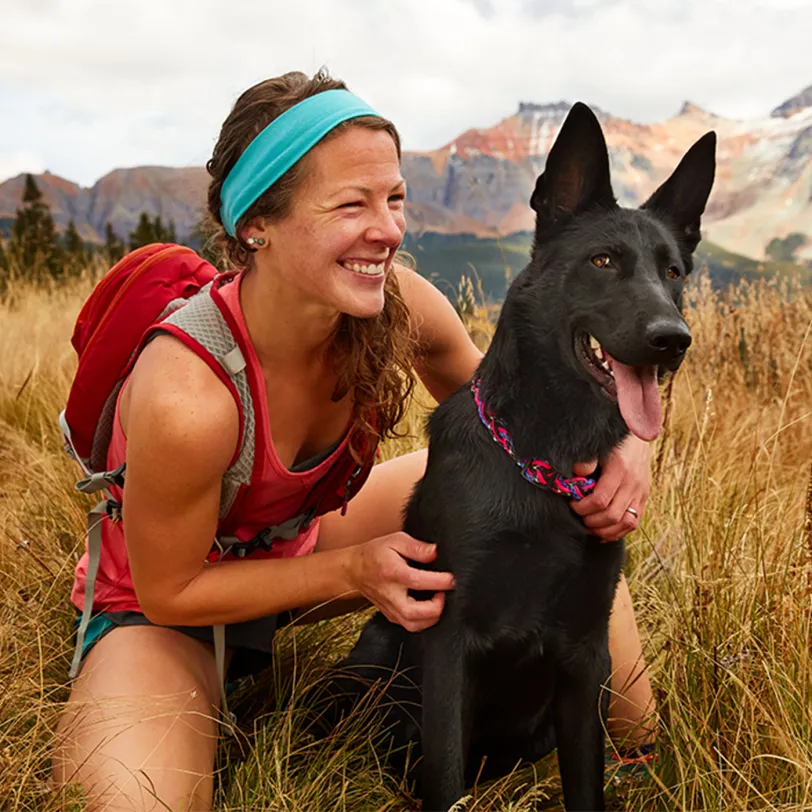 Woman and dog sitting in a field 